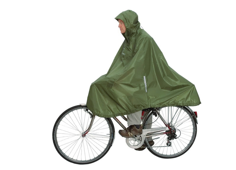 En man cyklar med regnponcho (grön cykelcape) till jobbet
