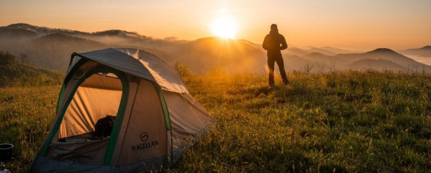 Tältcamping på en kulle, tittar ut över landskapet