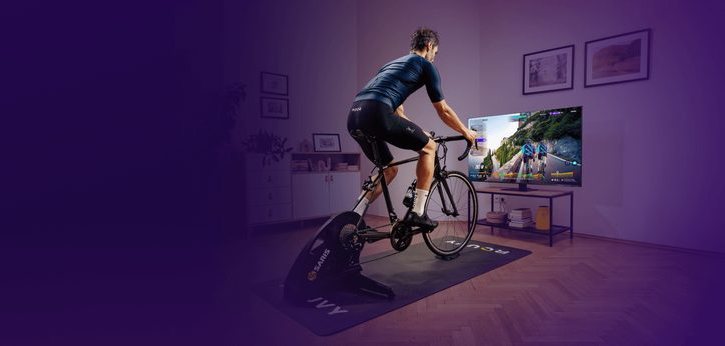 Cyklist på trainer framför TV med Rouvy igång