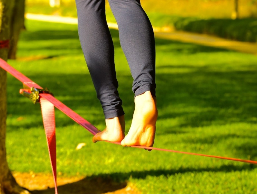 Röd slackline monterad i en park